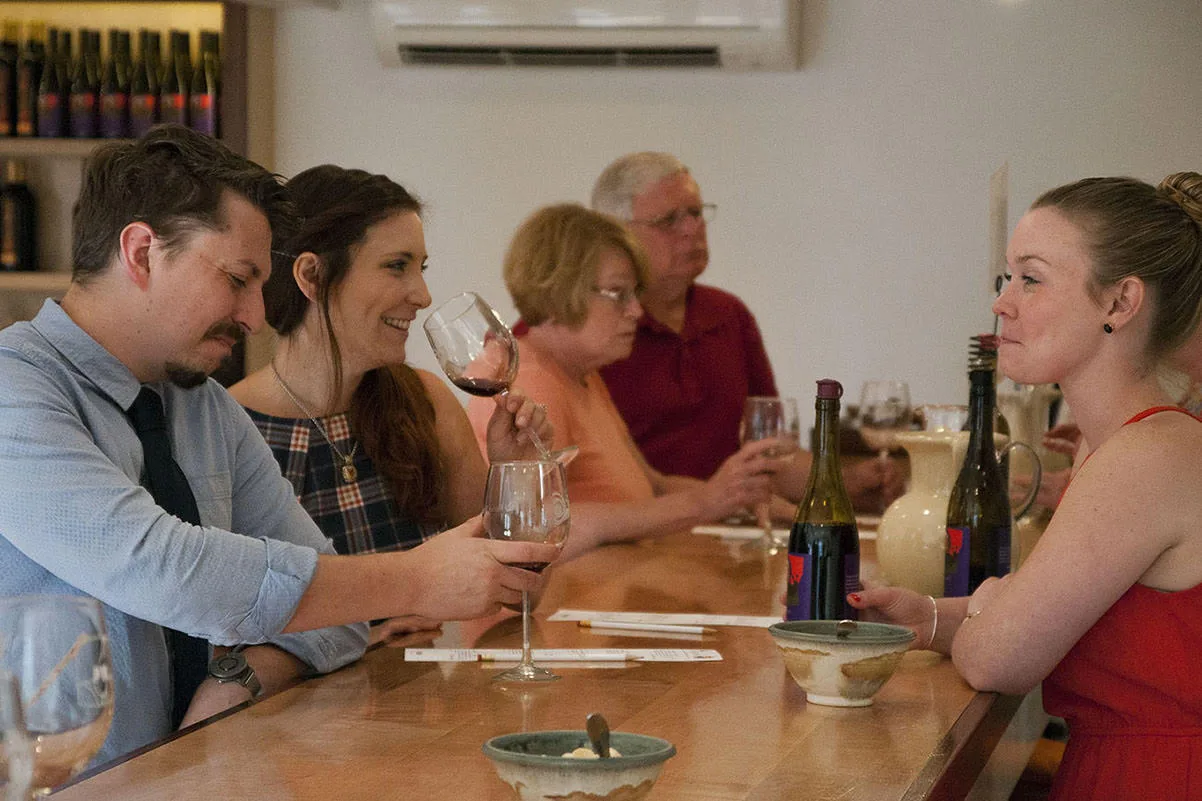 Guests tasting wine at the Hermit Woods Winery & Eatery tasting-room bar