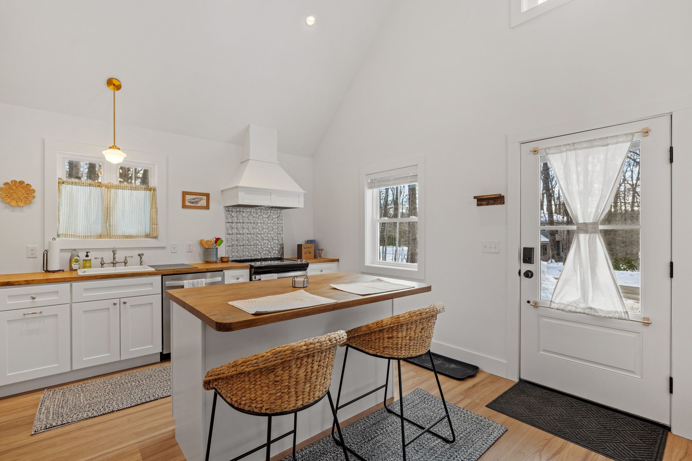 Kitchen with white cabinetry, butcher-block counters, and a center island