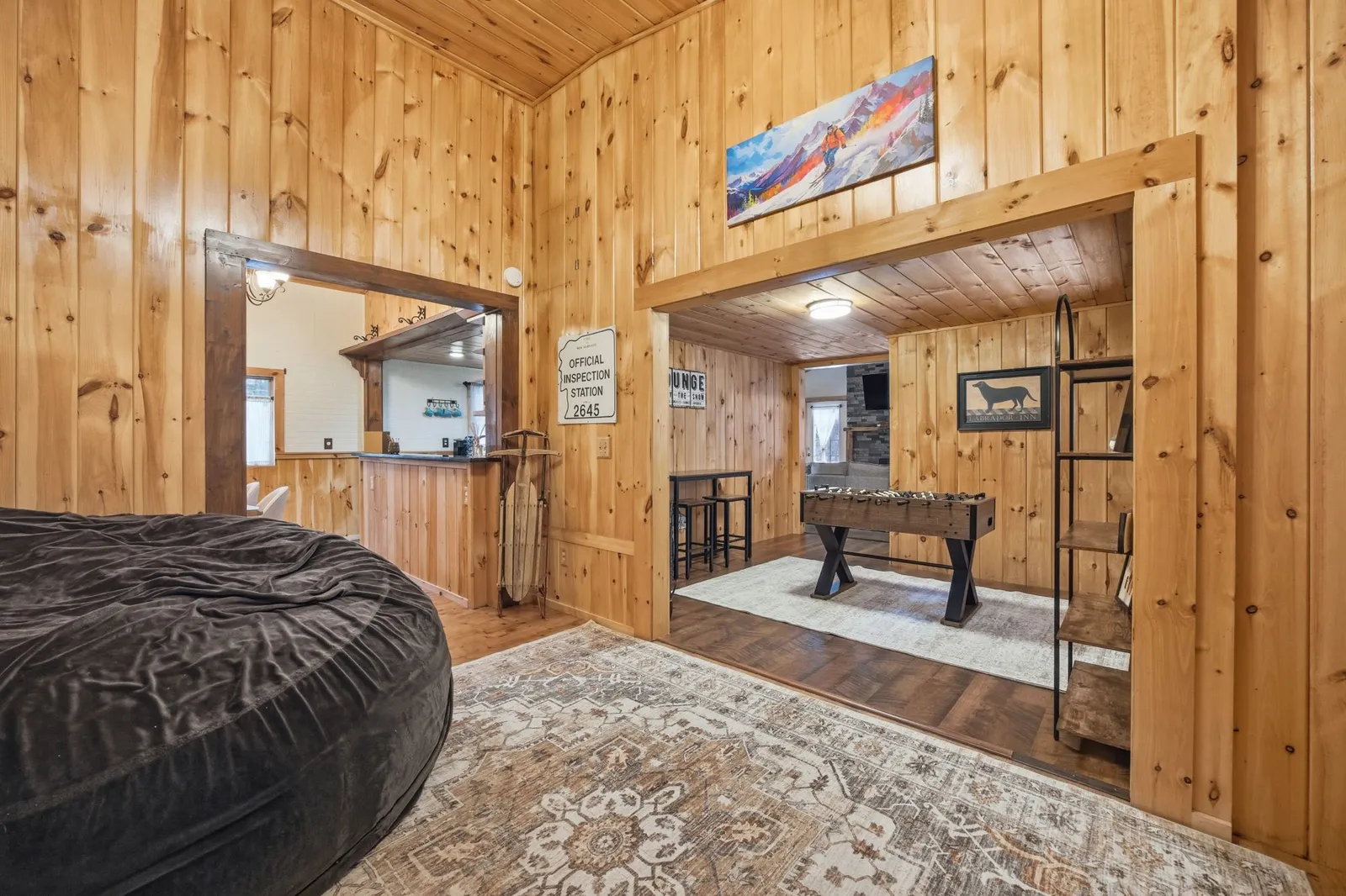 Lower-level lounge with a wet bar, foosball table, and bean bag seating